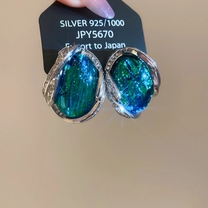 Vue macro détaillée des boucles d'oreilles vintage en résine émeraude avec bord en argent