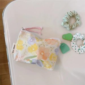 Detailed view of floral cotton mini pouch with zipper and decorative hair accessories