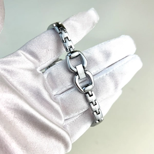 Close-up of silver button bracelet watch strap featuring unique horsebit style link design