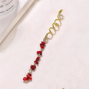Boho golden spiral hair ring with natural red stone pendant on textured background