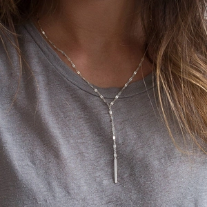 Elegant silver Y-shaped stainless steel drop necklace worn on minimalist clothing