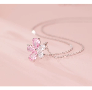 Macro detail of silver necklace with pink and white zircon stones in flower shape