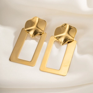 Elegant gold geometric earrings on white silk background with minimalist metallic design