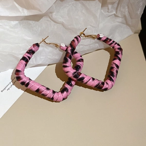 Gros plan sur les boucles d'oreilles carrées roses à imprimé léopard et fermoirs dorés