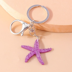 Close-up of a stylish silver keychain featuring a sparkling pink glitter starfish charm