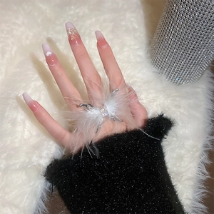 Detail of butterfly ring with white feathers and rhinestones on model finger