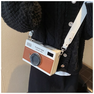 Close-up of retro camera-shaped crossbody bag with white and brown PU leather texture