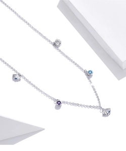 Macro detail of silver S925 shell necklace with blue and purple zirconia accents