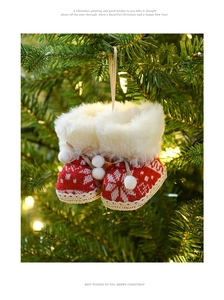 Macro detail of red knitted Christmas boot ornament with snowflake pattern on tree