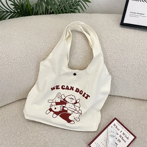 Détail du sac fourre-tout en toile blanc cassé avec imprimé dessin animé et bouton