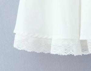 Détail de la dentelle blanche délicate sur l'ourlet d'une jupe pour femme en tissu doux