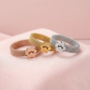 Detailed view of mesh band rings with paw prints in rose gold, gold, and silver