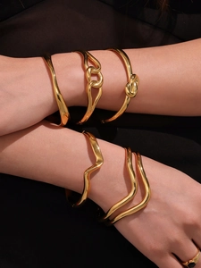 Detail shot of stacked wave pattern 18k gold plated stainless steel bangles for women