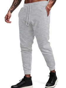 Detail of grey waffle knit joggers showing fabric texture, drawstring waist and side pockets
