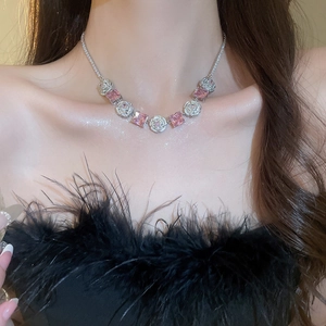 Close-up of elegant silver necklace with pink square zircons worn by a model