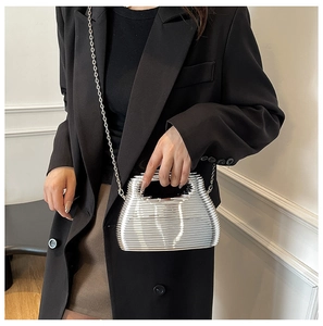 Detail of silver metallic chain handbag styled with a black blazer for a modern luxury look