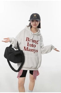 Detail of trendy gray oversized hoodie with burgundy graphic text in street style