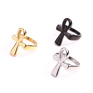 Detailed view of three polished stainless steel Ankh cross rings in gold, silver, and black