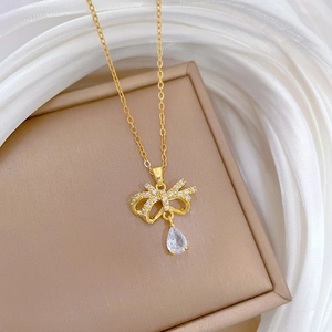 Detailed macro shot of gold butterfly necklace with crystal droplets on silk fabric