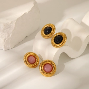 Détail de boucles d'oreilles martelées en or de style français avec pierres bleues et roses