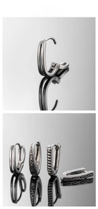 Detailed macro view of four vintage silver V-shaped stainless steel earrings with textures
