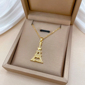 Eiffel Tower crystal necklace in gold finish with Love charm on velvet jewelry display