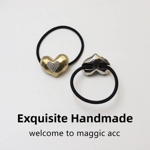 Detail of heart bear hair ties featuring matte gold rhinestone and silver metal textures