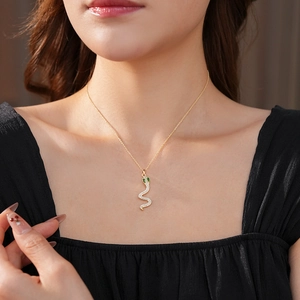 Primo piano di una collana di perle con ciondolo a serpente in zircone indossata da modella