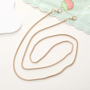 Detail view of a flexible gold snake chain with lobster clasps for crossbody phone cases