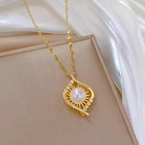 Elegant gold titanium necklace with bird nest pearl pendant and crystal accents