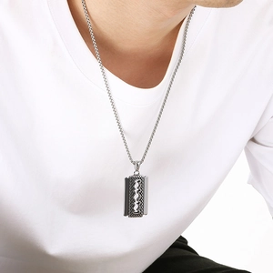 Men's punk razor blade pendant necklace in polished silver stainless steel on a white tee