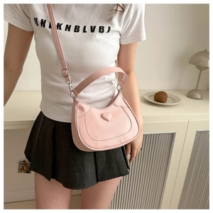 Detail shot of the pink heart-shaped saddle bag with smooth PU leather finish