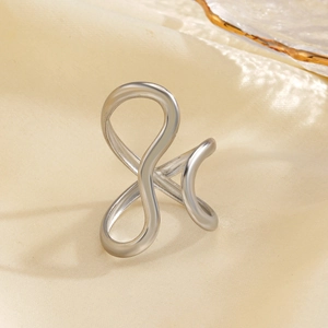 Minimalist silver wavy crisscross open ring made of stainless steel on silk background