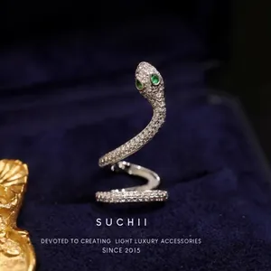 Bague spirale en forme de serpent argenté avec zircons et yeux en pierre verte