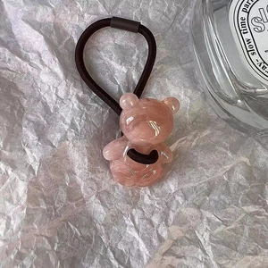 Détail macro d'un chouchou ours rose en résine avec élastique noir haute résistance