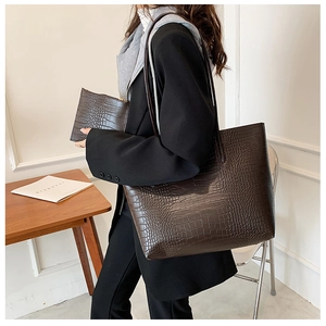 Dark brown crocodile pattern tote bag set with matching pouch shown on a model