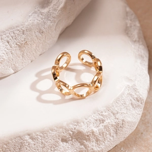 Macro di anello aperto dorato con maglie ovali su pietra bianca, design minimalista