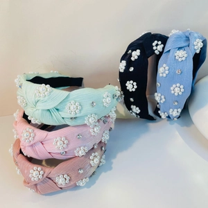 Nahaufnahme von Satin-Haarreifen mit Perlenblumen-Muster und funkelnden Strasssteinen