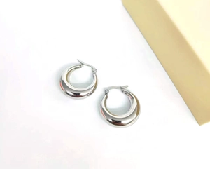 Detail of silver chunky hollow hoop earrings made of polished stainless steel