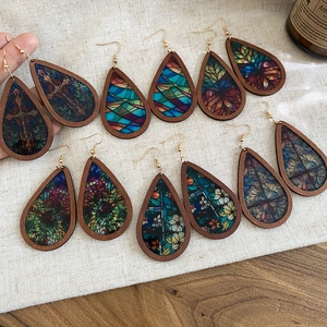 Detail of wooden teardrop earrings with colorful vintage patterns on linen background