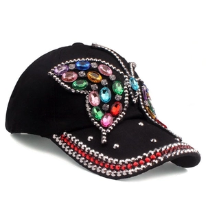 Close-up of a black denim baseball cap with colorful butterfly rhinestone embellishments