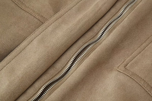 Macro detail of camel suede jacket featuring silver metal zipper and precise topstitching