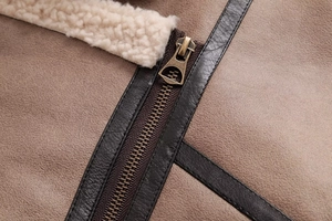 Detailed macro view of a vintage brown suede jacket with metal zipper and faux shearling lining