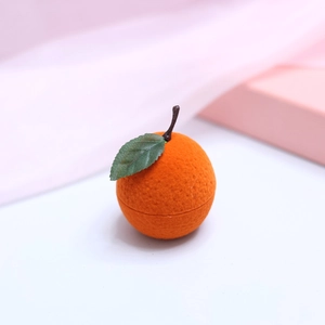 Detailed view of the cute orange-shaped jewelry box showing texture and green leaf detail