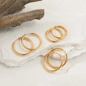 Three pairs of minimalist polished golden titanium steel hoop earrings in varied sizes