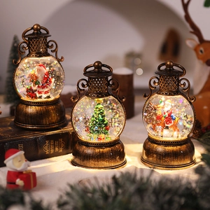 Close-up of three vintage bronze Christmas lanterns with glowing Santa snow globe scenes
