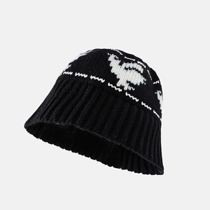 Detail of knitted bucket hat featuring black and white sheep pattern and soft texture