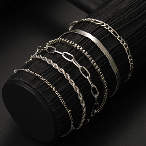 Close-up of silver chain bracelet set featuring Figaro, Herringbone, and Rope styles