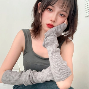 Detail of light gray ribbed knit arm sleeves with soft texture shown on arm