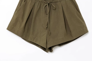 Detail of army green casual shorts featuring elastic drawstring waist and side pockets